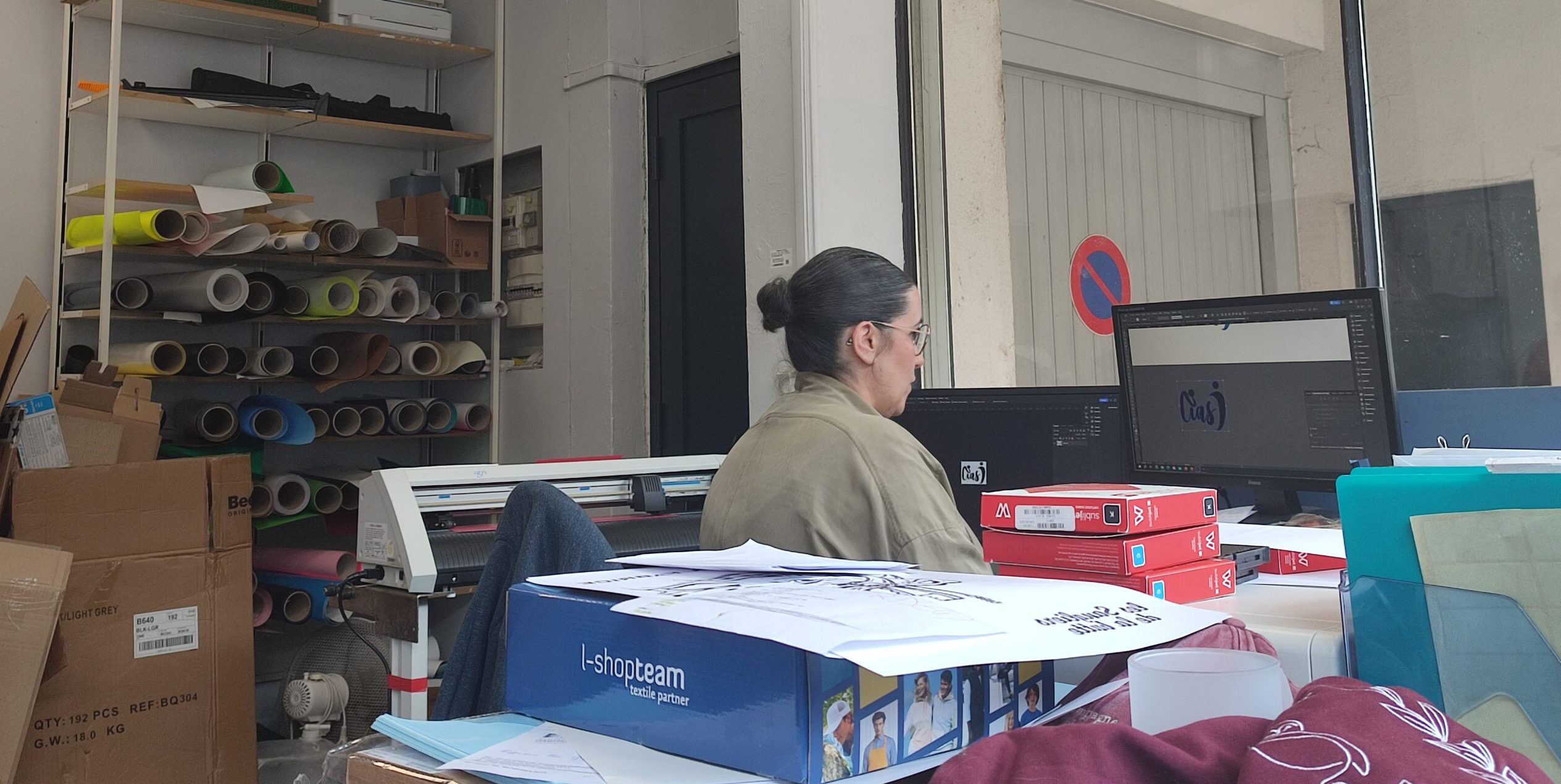 Graphiste de Swaag Shirt créant un logo à l'ordinateur dans l'atelier